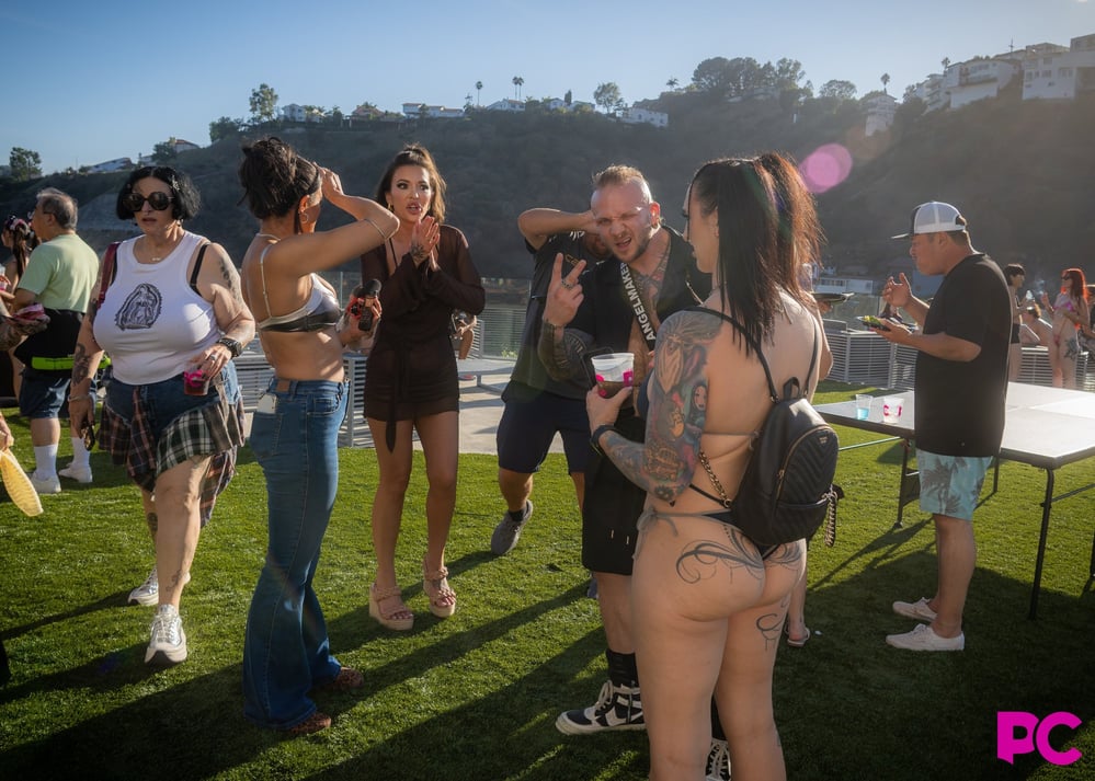 Guests talk on the lawn at the fourth annual PornCrush pool party, with the Hollywood Hills behind them.